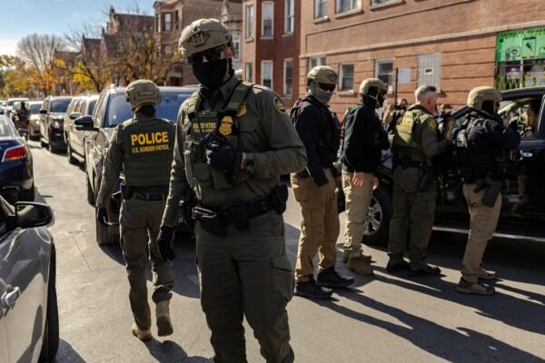PHOTO: Federal agents confront community members during immigration raids